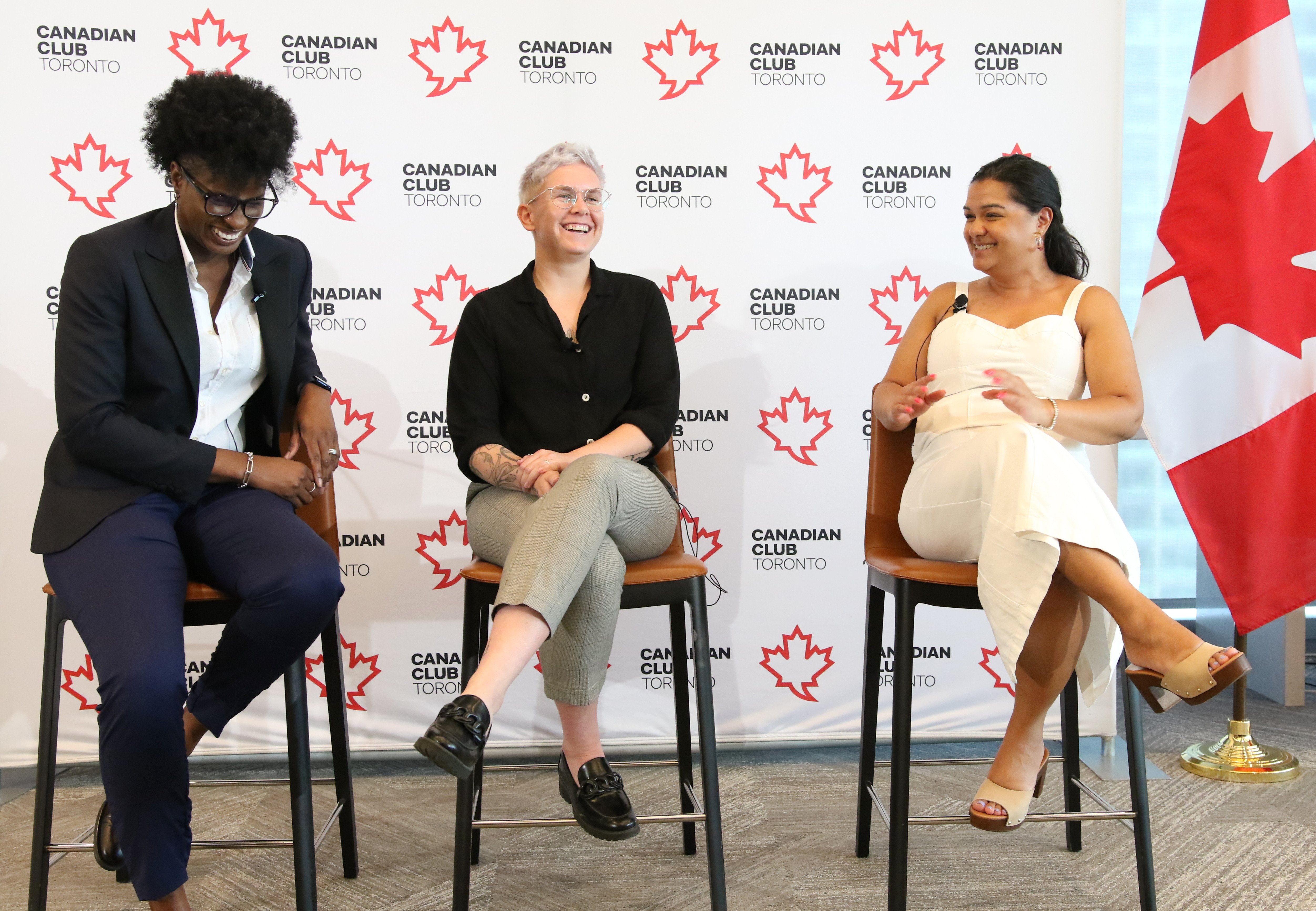 Three adult humans sitting in chairs and talking